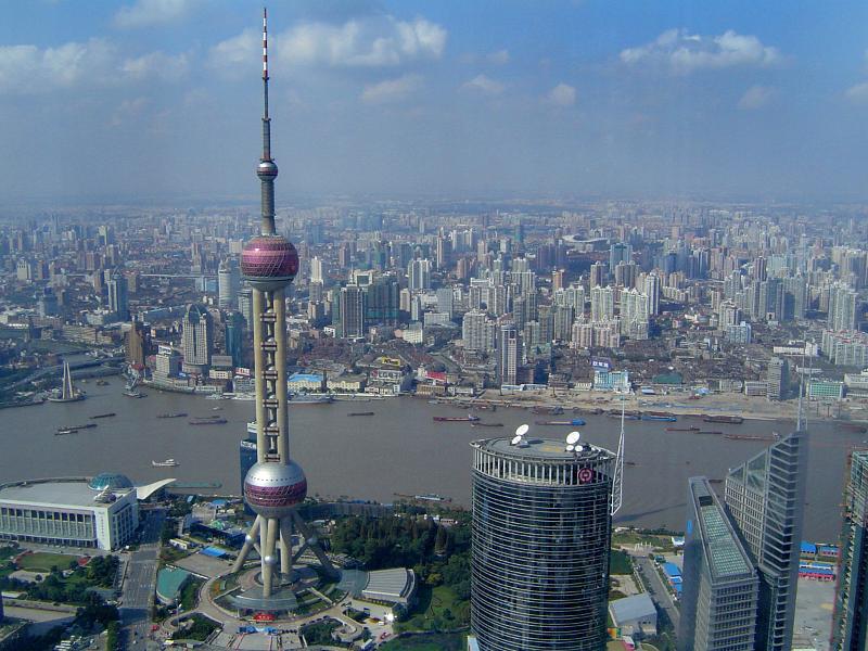 Aerial cityscape of the city of Shanghai with the river and Oriental Pearl Tower in the foreground showing the topography and architecture